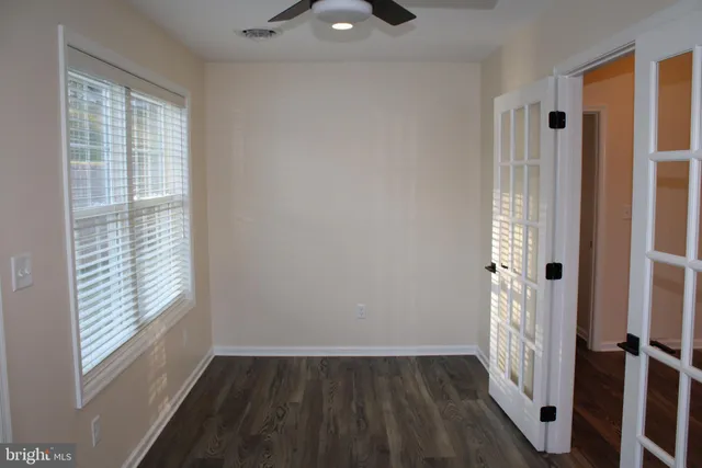 a large room with a refrigerator a couch and chandelier