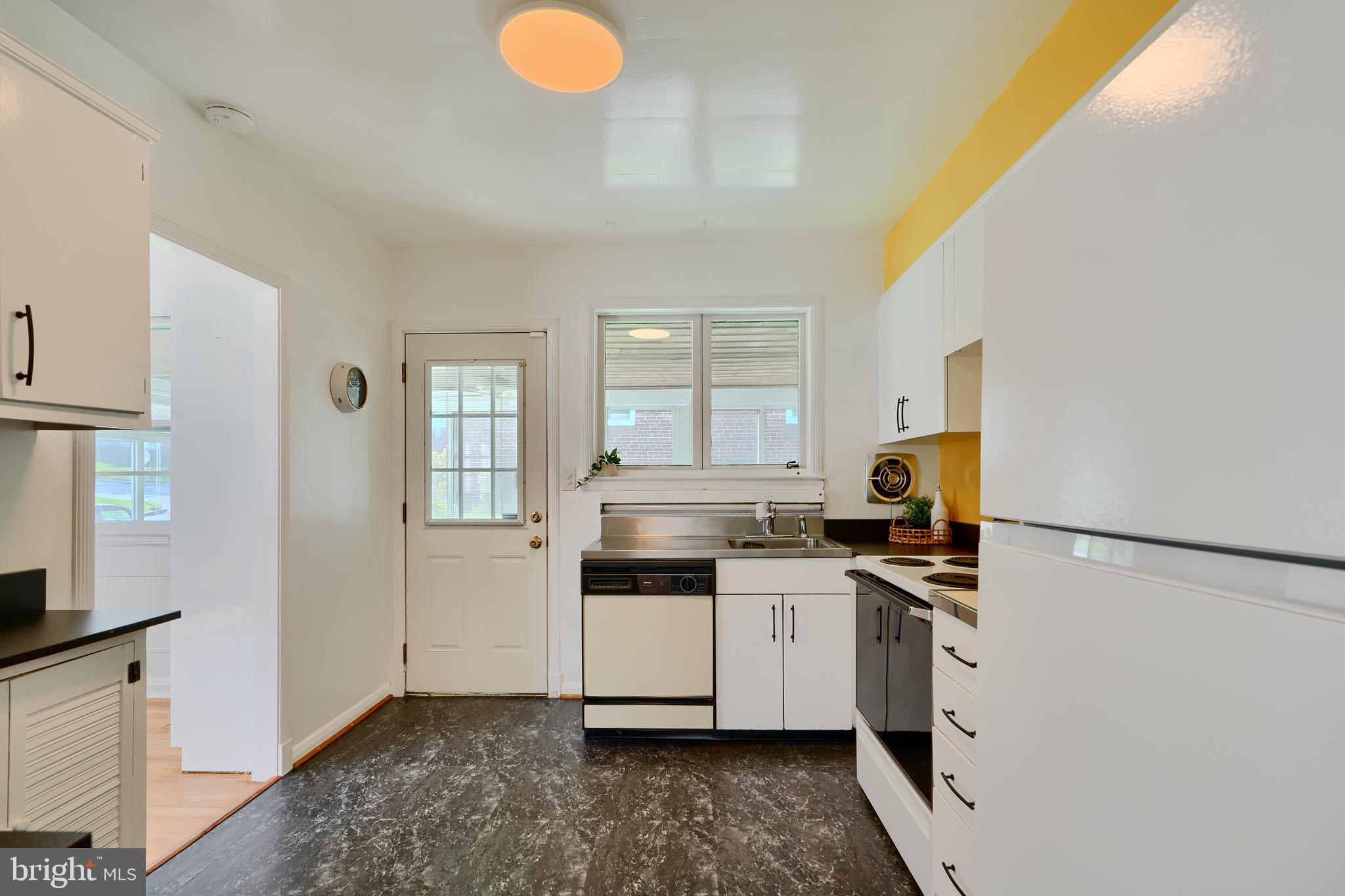 1316 Glendale Road Baltimore, MD 21239 - Photo 14 of 37 a kitchen with a sink a stove top oven and white stainless steel appliances