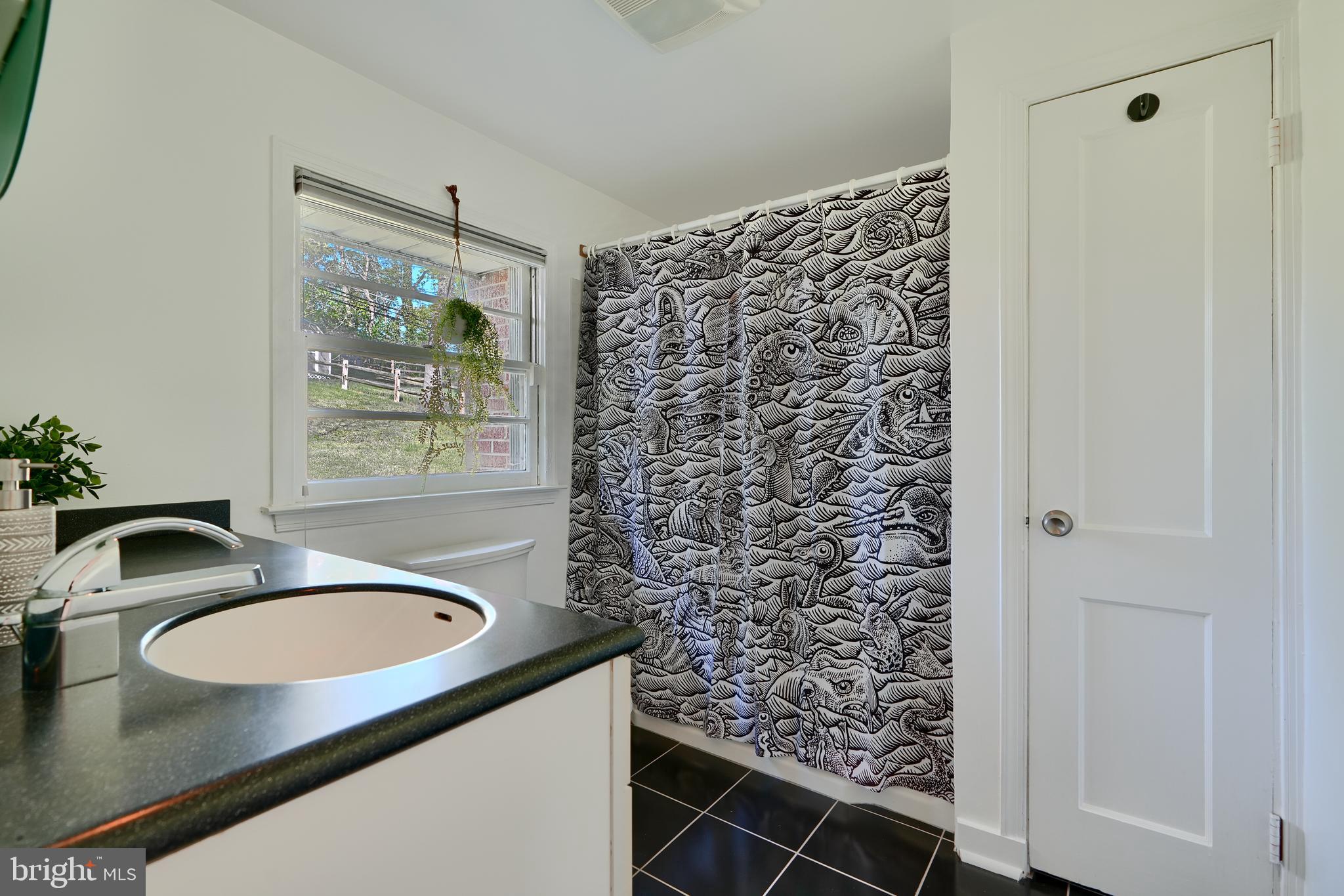 1316 Glendale Road Baltimore, MD 21239 - Photo 24 of 37 a bathroom with a granite countertop sink and a mirror