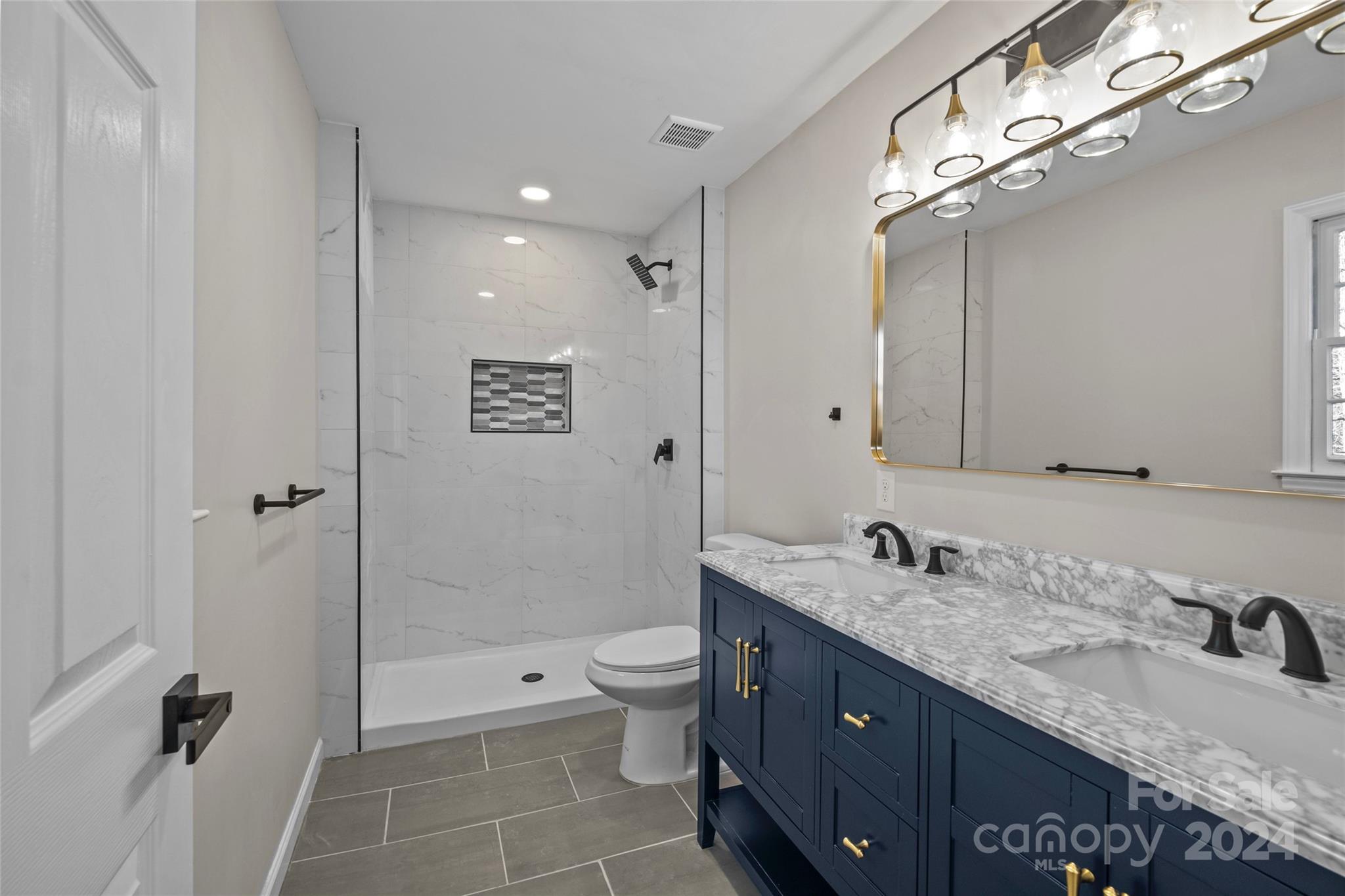5808 Woody Grove Road Indian Trail, NC 28079 - Photo 16 of 30 a bathroom with a granite countertop sink a toilet a mirror and shower