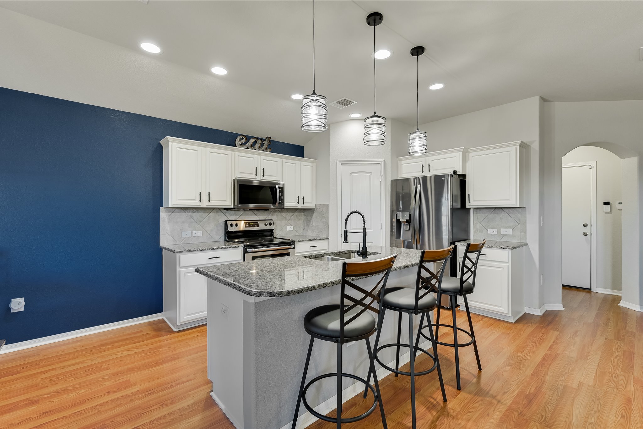 725 Pinnacle Drive Georgetown, TX 78626 - Photo 5 of 20 a kitchen with stainless steel appliances kitchen island granite countertop a table chairs refrigerator and microwave