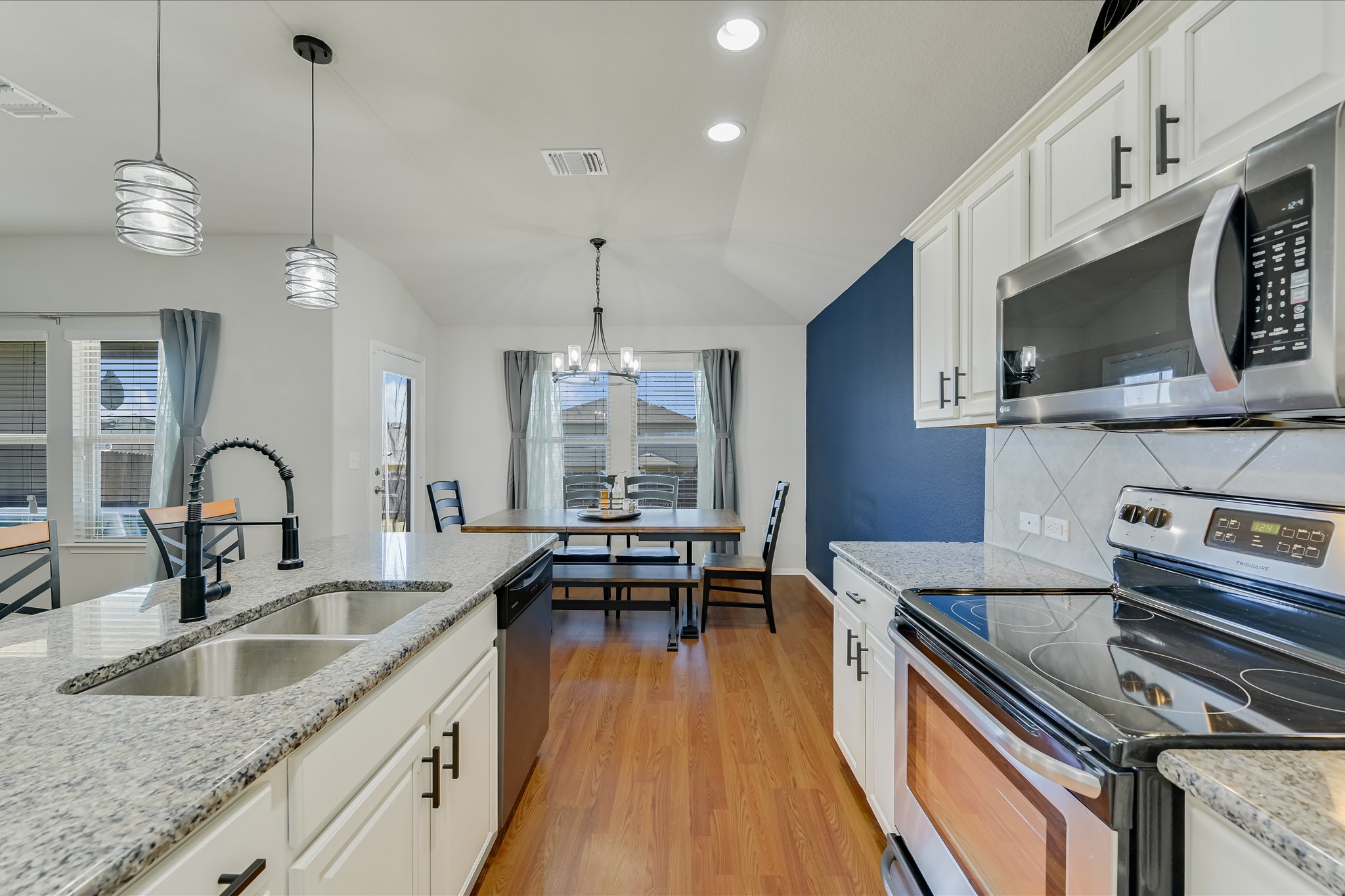 725 Pinnacle Drive Georgetown, TX 78626 - Photo 7 of 20 a kitchen with stainless steel appliances granite countertop a sink a stove and a wooden floors
