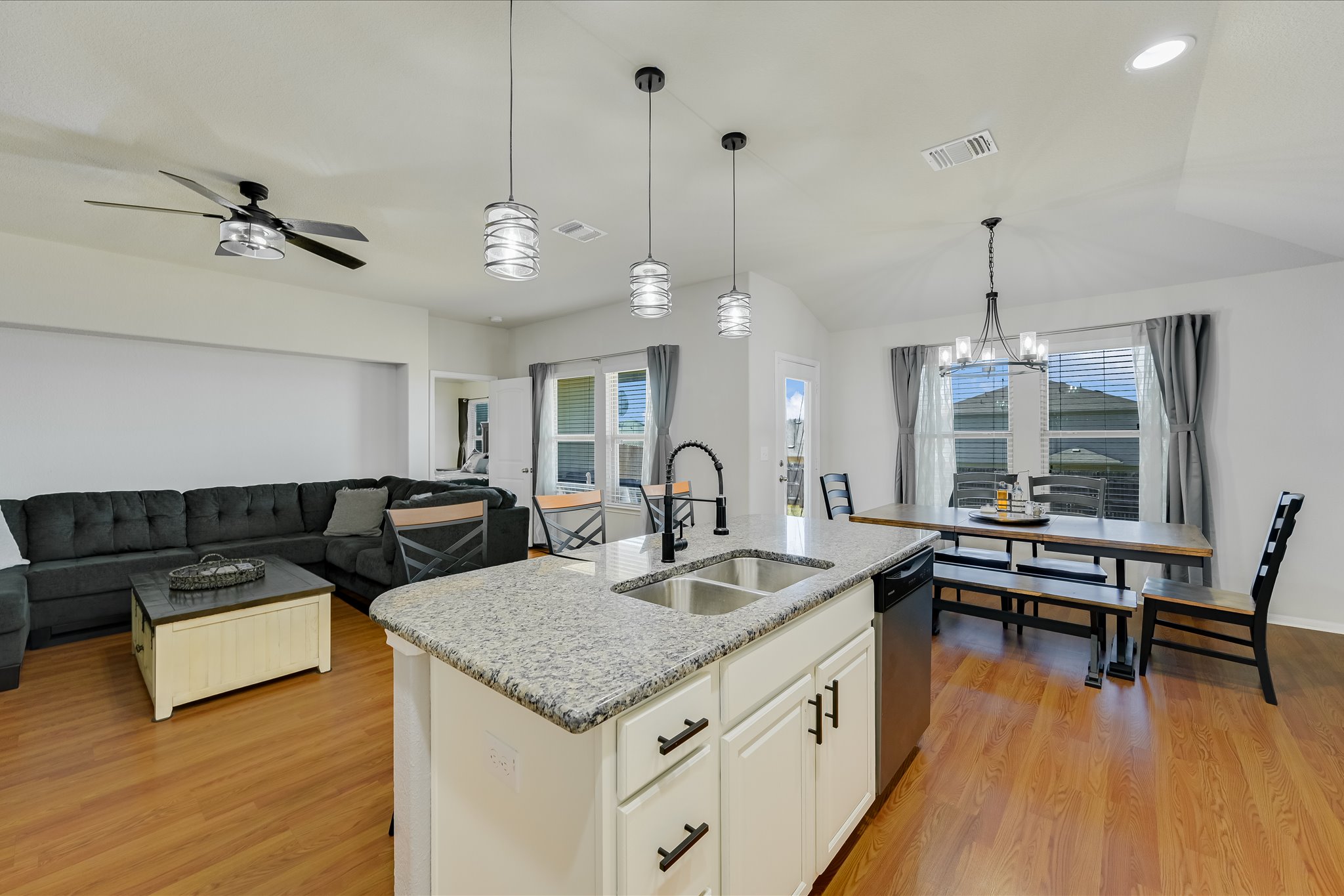 725 Pinnacle Drive Georgetown, TX 78626 - Photo 20 of 20 a open kitchen with stainless steel appliances granite countertop a kitchen island a stove a dining table and chairs with wooden floor