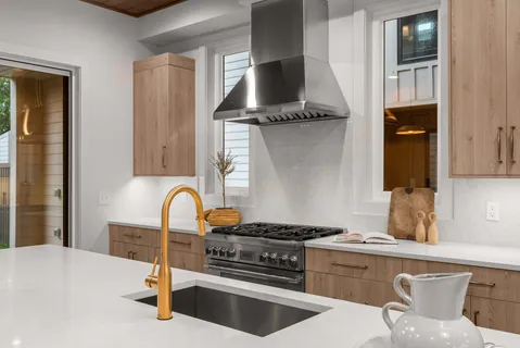 a kitchen with stainless steel appliances kitchen island a stove and a sink
