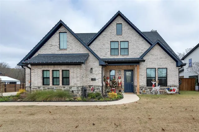 a front view of a house with a yard and potted plants