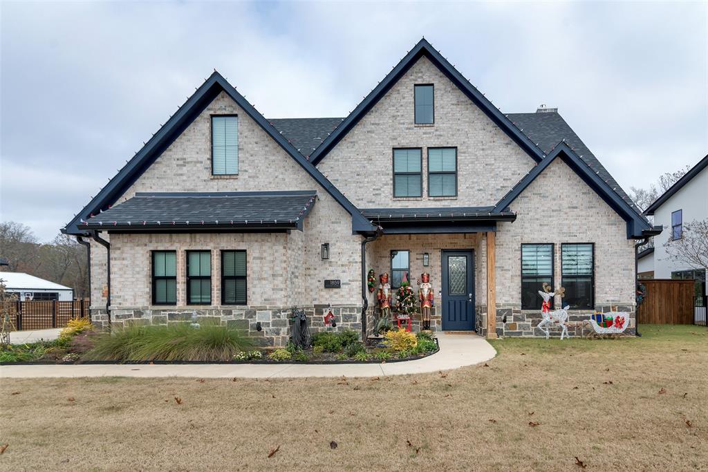 a front view of a house with a yard and potted plants