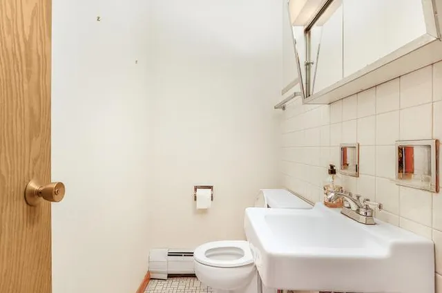 a bathroom with a sink toilet and a mirror