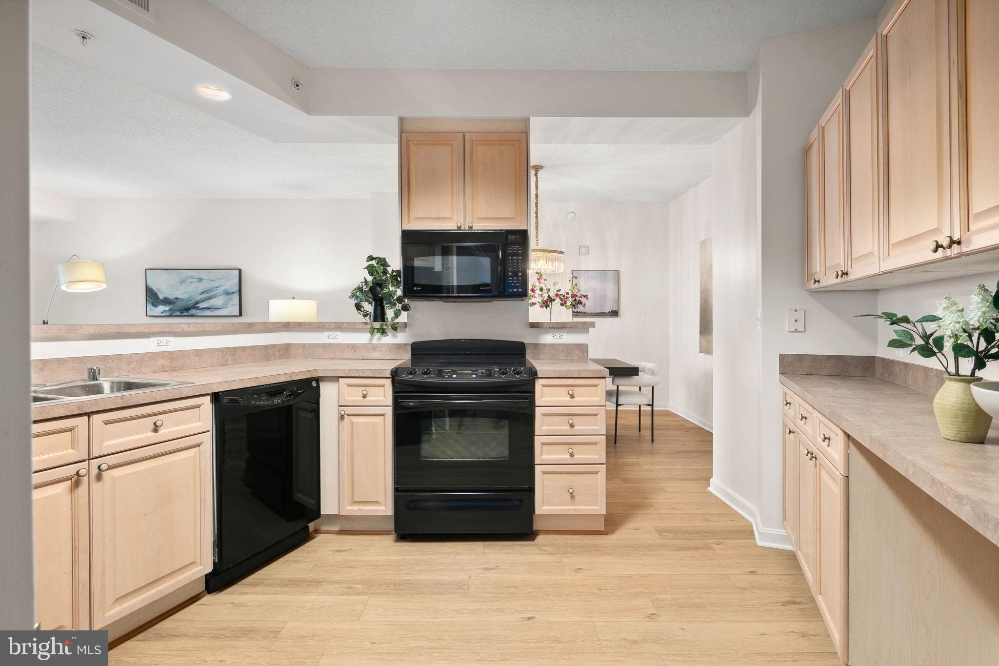 19355 Cypress Ridge Terrace, Unit 803 Leesburg, VA 20176 - Photo 17 of 38 a kitchen with granite countertop a stove top oven and cabinets