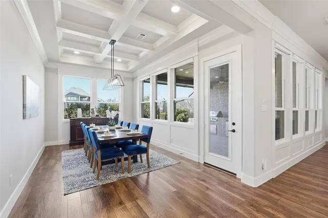 a dining room with wooden floor a chandelier