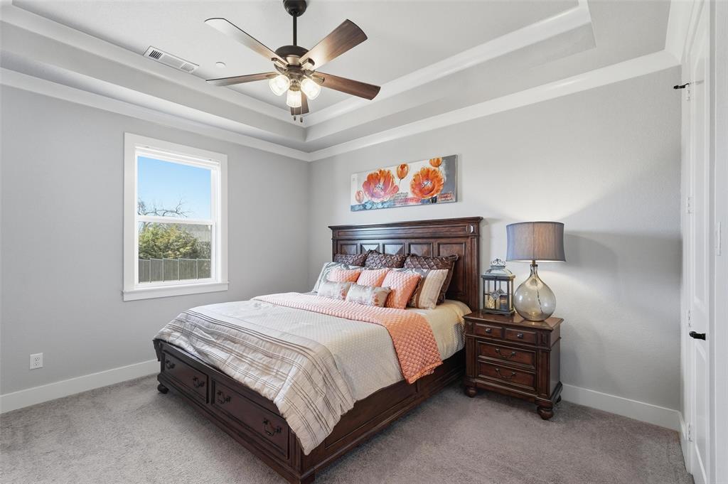 640 Maggie Trail Lucas, TX 75002 - Photo 23 of 40 a bedroom with a bed and a chandelier