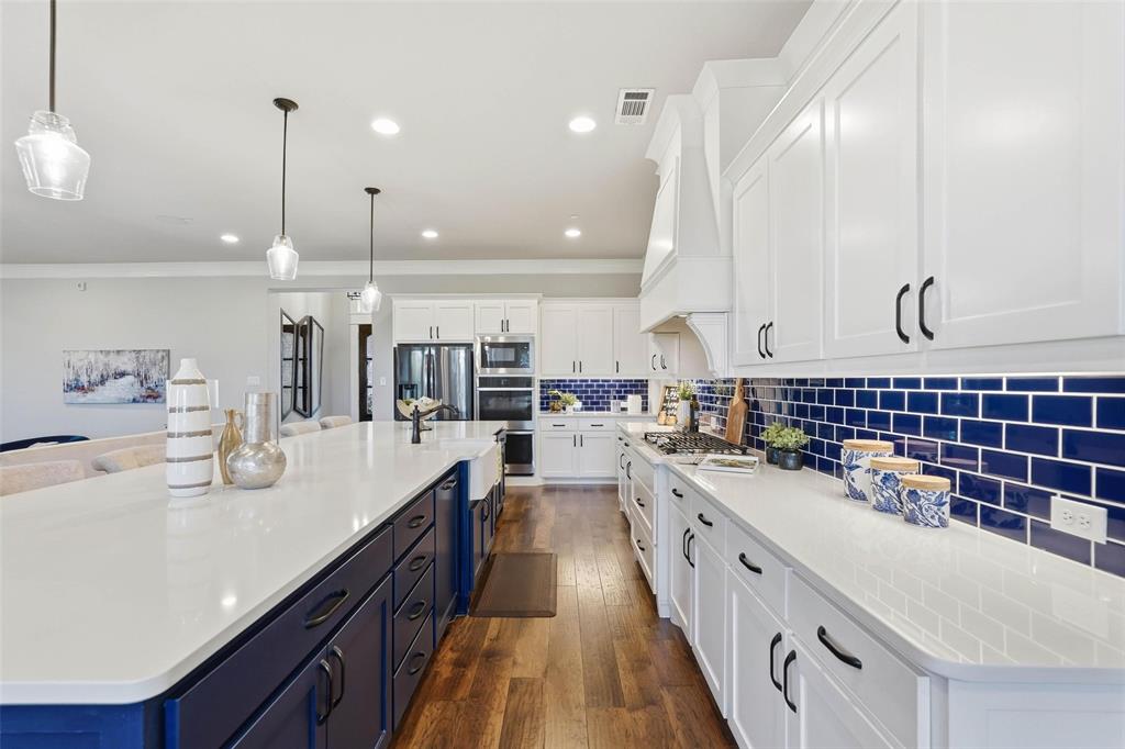 640 Maggie Trail Lucas, TX 75002 - Photo 8 of 40 a large kitchen with kitchen island a large counter space a sink stainless steel appliances and cabinets