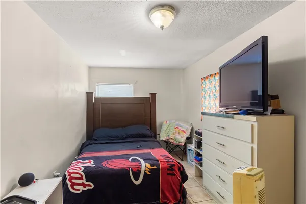 a bedroom with a bed and a mirror on the dresser