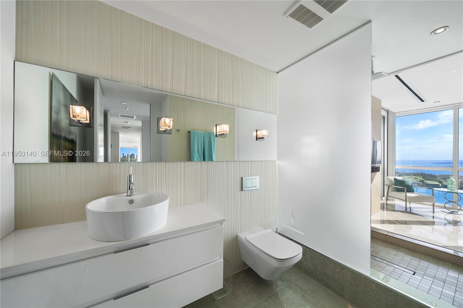 450 Alton Road, Unit PH1 Miami Beach, FL 33139 - Photo 78 of 98 a bathroom with a toilet a sink and mirror