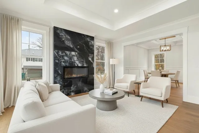 a living room with furniture a fireplace and a large window