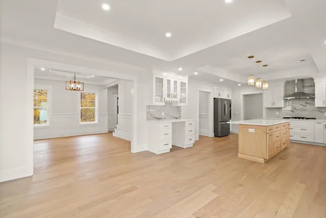 a view of kitchen with kitchen island white cabinets and wooden floor