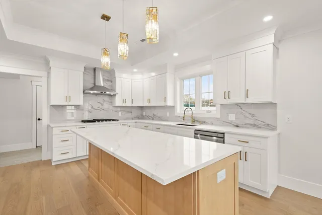 a kitchen with kitchen island a stove a sink a center island and cabinets