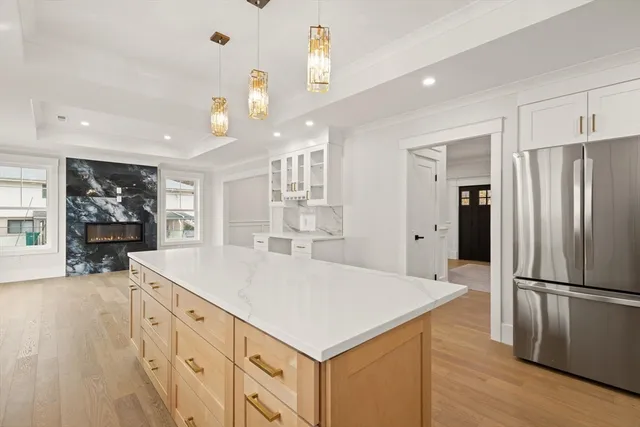 a kitchen with granite countertop a refrigerator a sink dishwasher and a stove with wooden floor