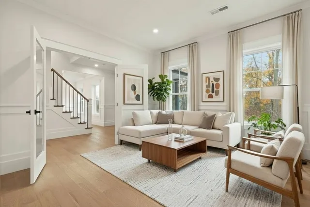 a living room with furniture wooden floor and a large window