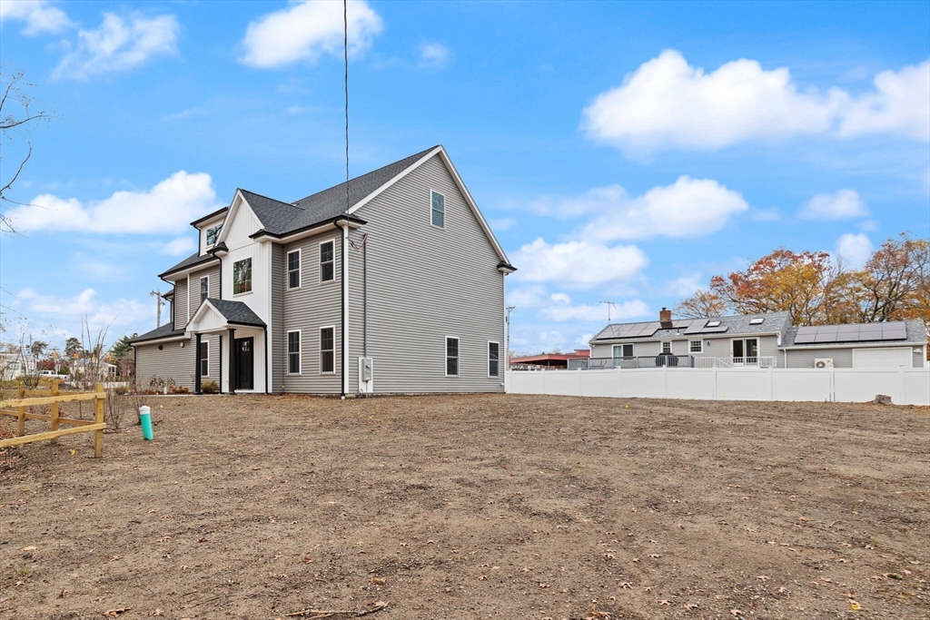 44 Buffington Street Attleboro, MA 02703 - Photo 40 of 41 a view of a white house with a big yard and large trees