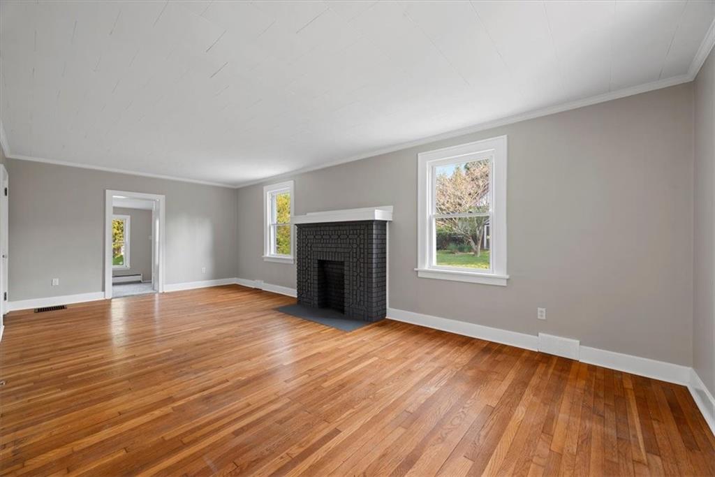 373 Goldsmith Road Pittsburgh, PA 15237 - Photo 7 of 40 an empty room with wooden floor fireplace and windows