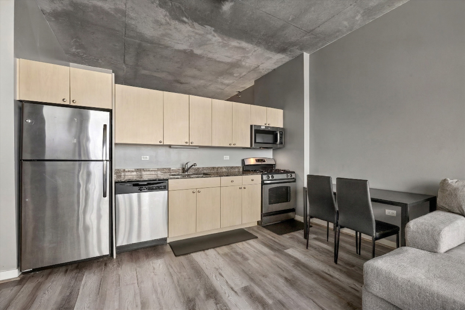 235 West Van Buren Street, Unit 2513 Chicago, IL 60607 - Photo 7 of 18 a kitchen with a refrigerator a stove top oven a sink and white cabinets with wooden floor
