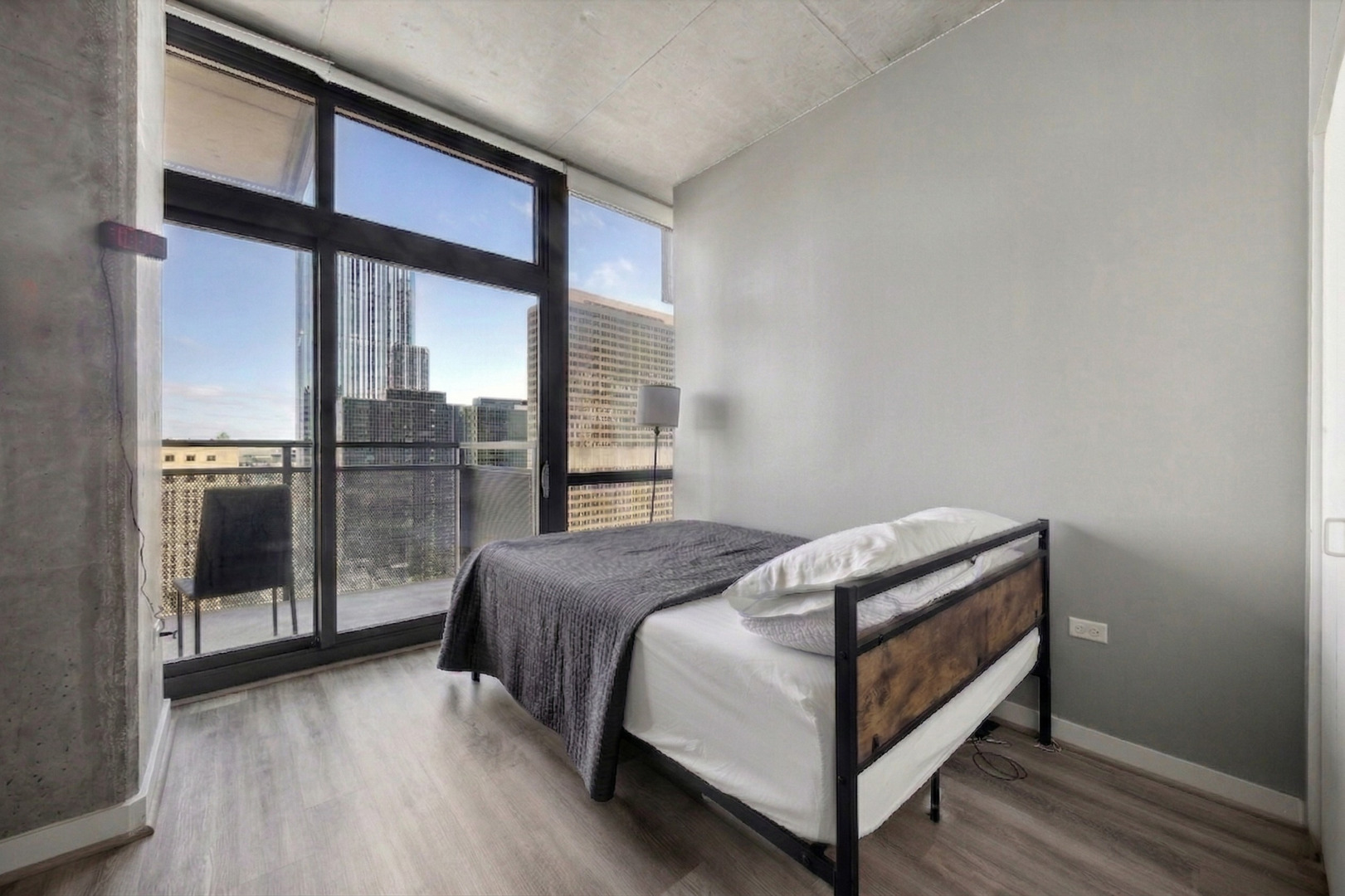 235 West Van Buren Street, Unit 2513 Chicago, IL 60607 - Photo 8 of 18 a bed sitting in a bedroom next to a balcony