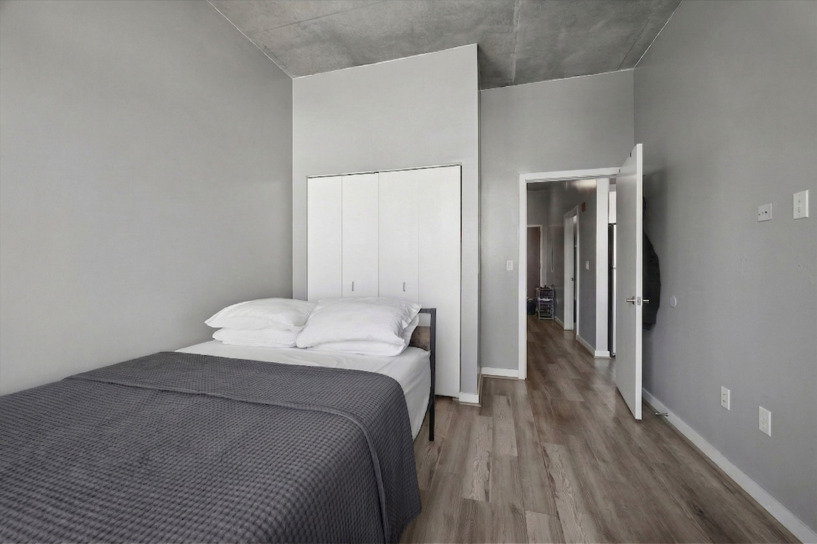 235 West Van Buren Street, Unit 2513 Chicago, IL 60607 - Photo 9 of 18 a bedroom with a bed and wooden floor