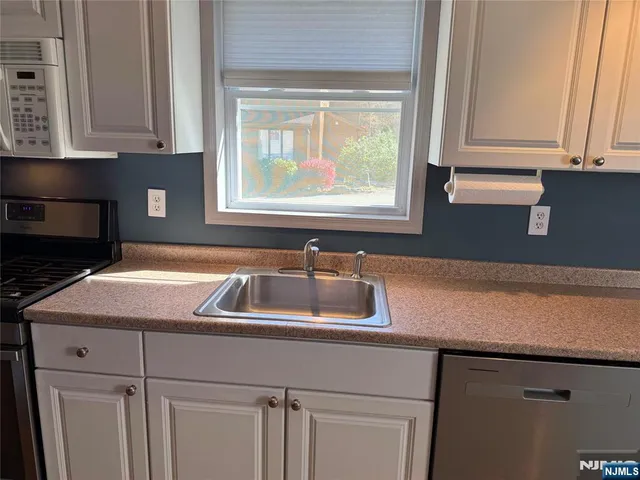 a kitchen with a sink cabinets and a window