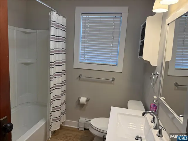 a bathroom with a toilet and a shower curtain