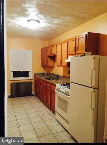 a kitchen with stainless steel appliances a refrigerator sink and cabinets