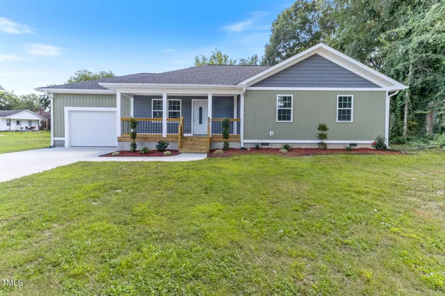 a front view of a house with a garden and porch