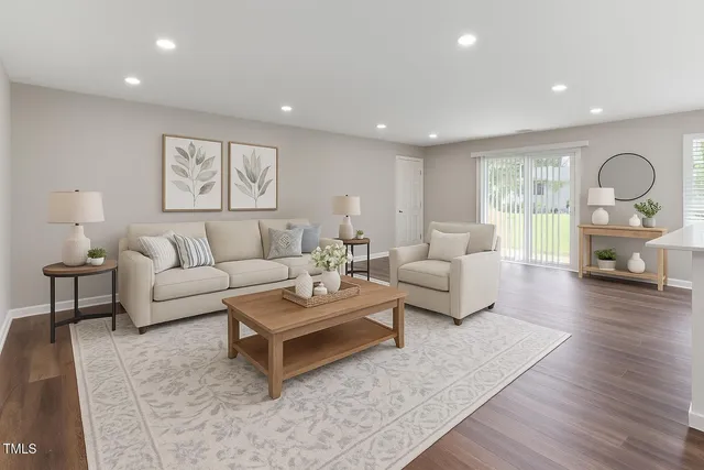 a living room with furniture and a wooden floor