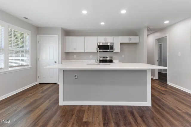 a large kitchen with stainless steel appliances a sink dishwasher a stove and a refrigerator