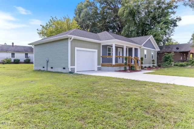a view of a house with a yard and sitting area