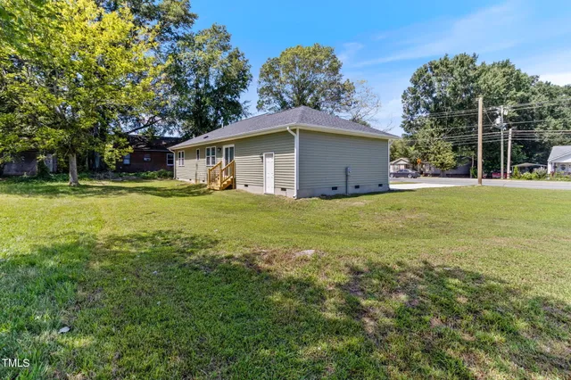 a big white house with a yard and large trees