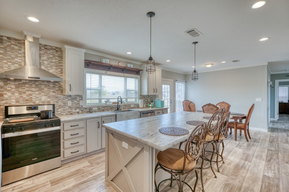 101 Samuel Drive Bertram, TX 78605 - Photo 12 of 30 a kitchen with a dining table chairs stainless steel appliances and cabinets