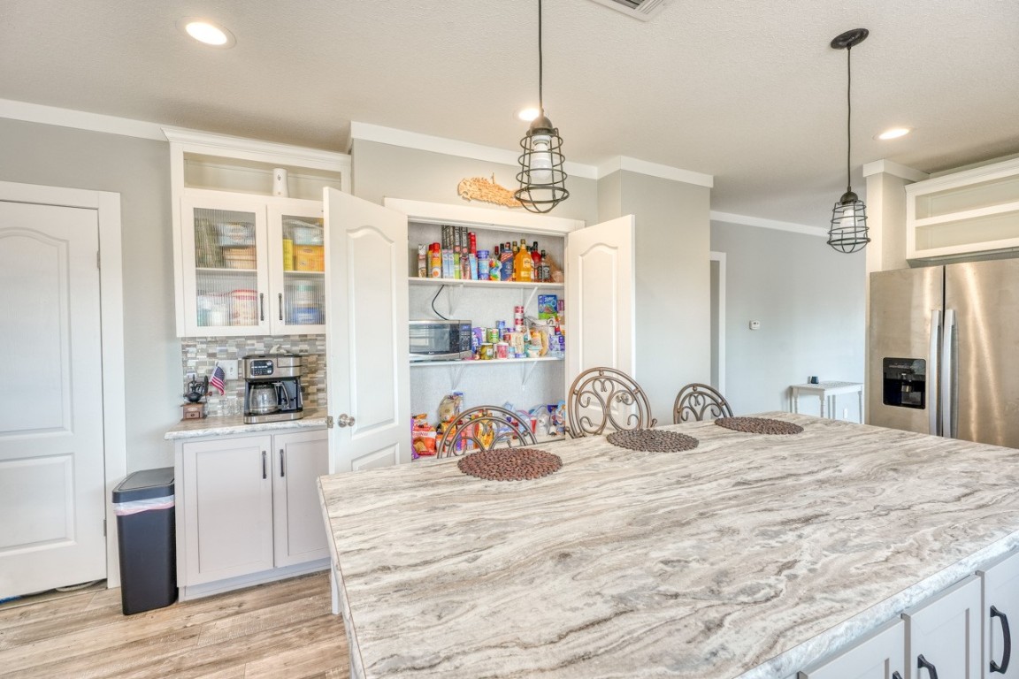 101 Samuel Drive Bertram, TX 78605 - Photo 13 of 30 a kitchen with kitchen island a sink appliances and wooden floor