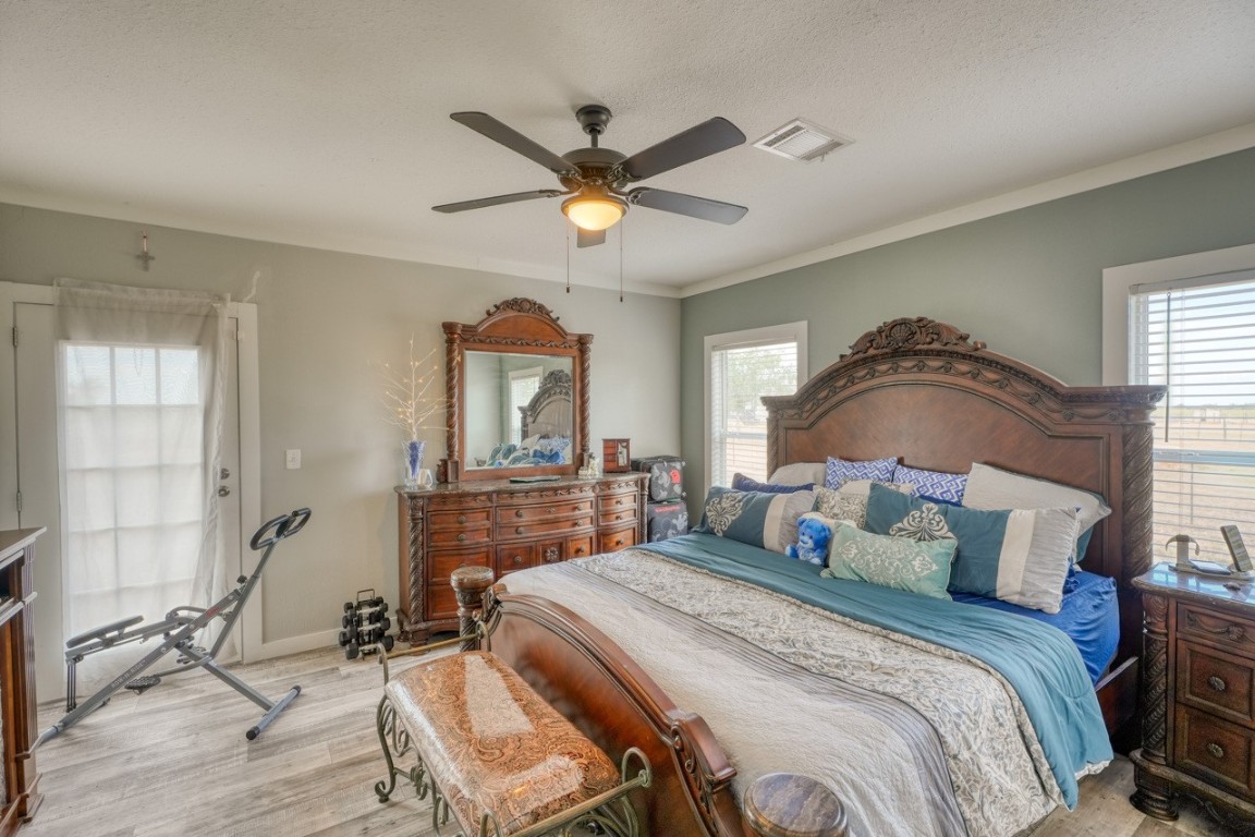 101 Samuel Drive Bertram, TX 78605 - Photo 19 of 30 a bedroom with a bed and a chandelier