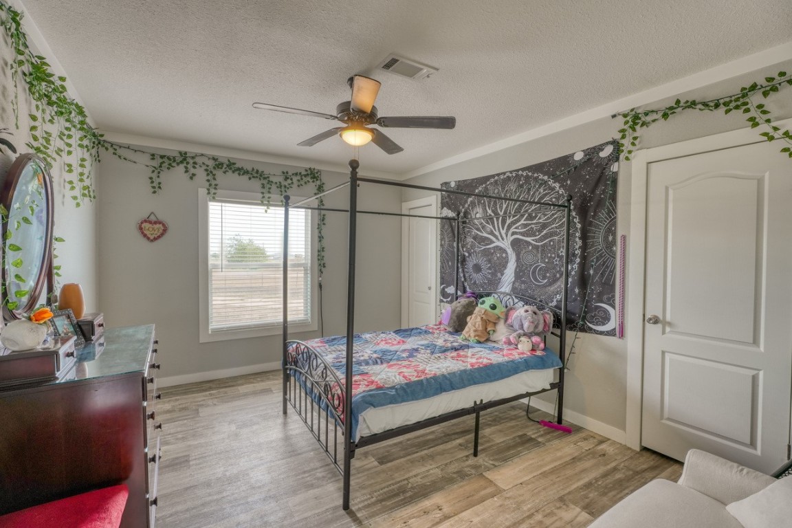 101 Samuel Drive Bertram, TX 78605 - Photo 26 of 30 a bedroom with a bed and a chandelier