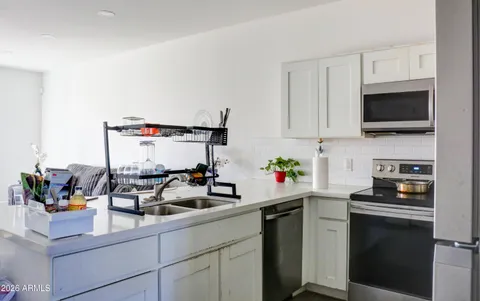 a kitchen with white cabinets and appliances