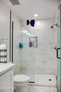 a bathroom with a sink a toilet and shower