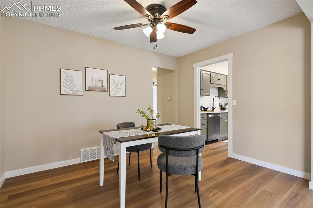 79 Old Broadmoor Road Colorado Springs, CO 80906 - Photo 12 of 27 Dining space featuring light wood-style flooring, a ceiling fan, an office area, and a textured ceiling