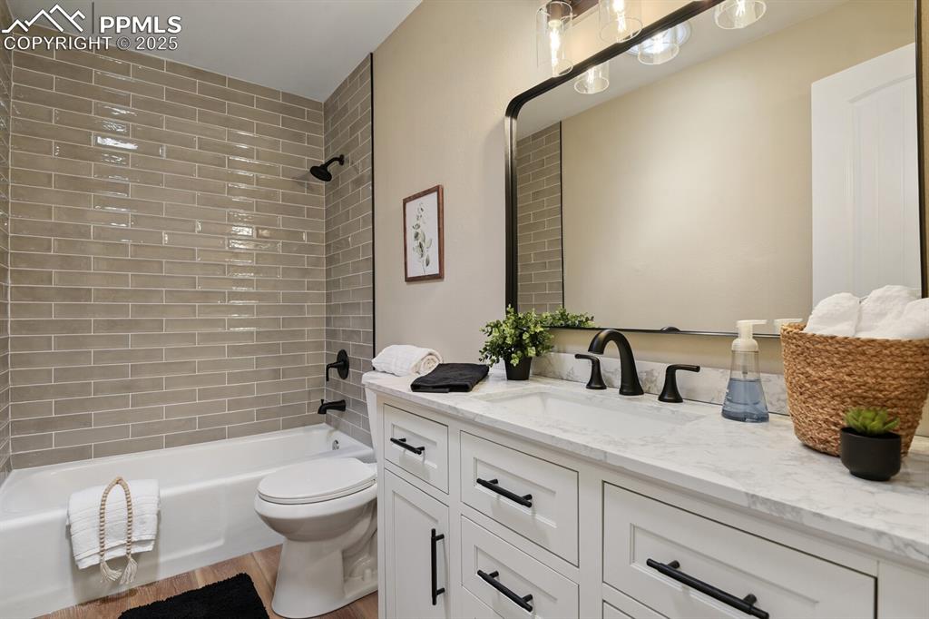 79 Old Broadmoor Road Colorado Springs, CO 80906 - Photo 20 of 27 Bathroom featuring vanity, washtub / shower combination, and wood finished floors
