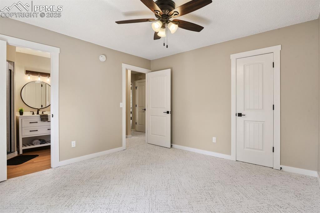 79 Old Broadmoor Road Colorado Springs, CO 80906 - Photo 22 of 27 Unfurnished bedroom with ensuite bath, carpet floors, and a ceiling fan