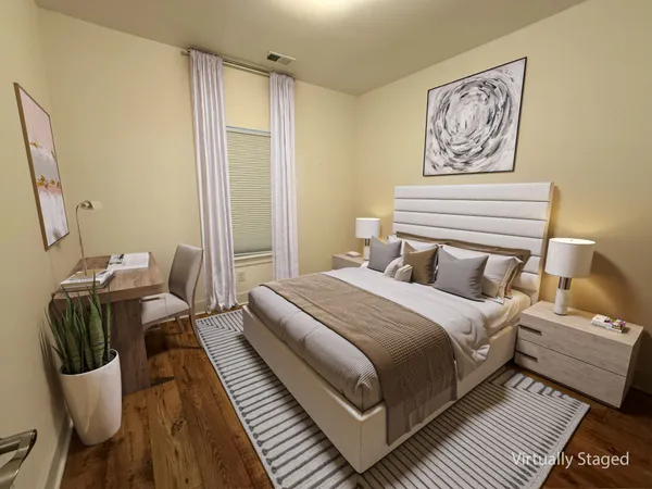 a bedroom with a bed and wooden floor