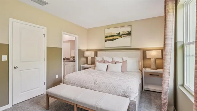 a bedroom with a large bed and painting on the wall