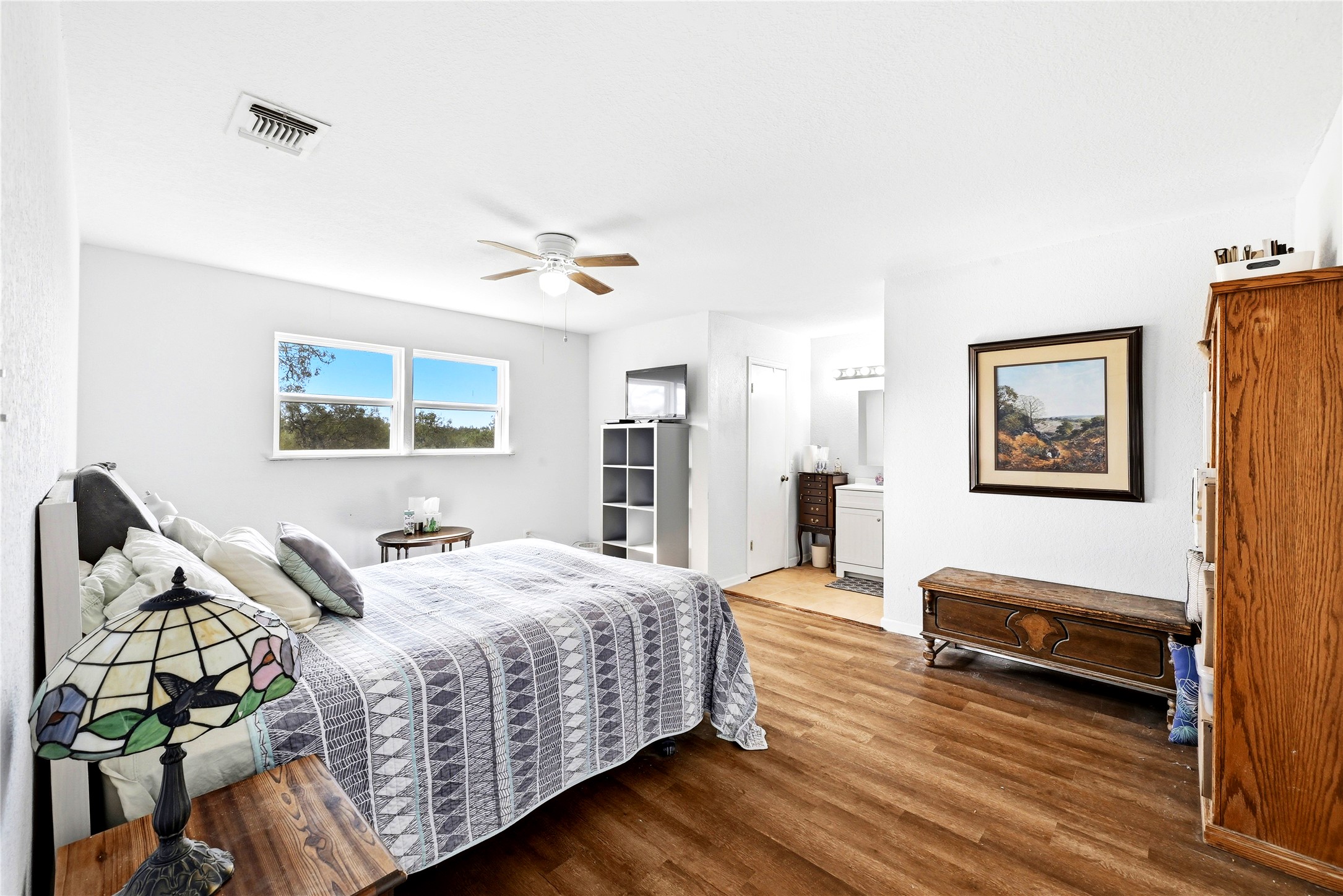 311 Salt Lake Road Luling, TX 78648 - Photo 4 of 37 Rich wood floors and abundant natural light create a welcoming atmosphere in this primary bedroom suite.