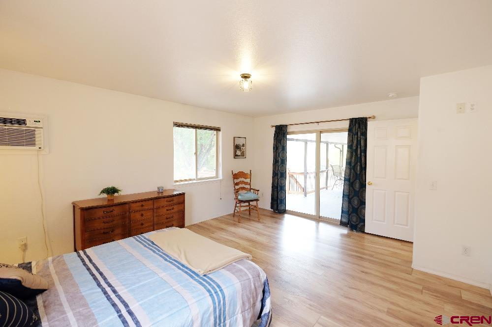 14135 N73 Road Montrose, CO 81401 - Photo 11 of 29 a bedroom with a bed and a dresser next to a window