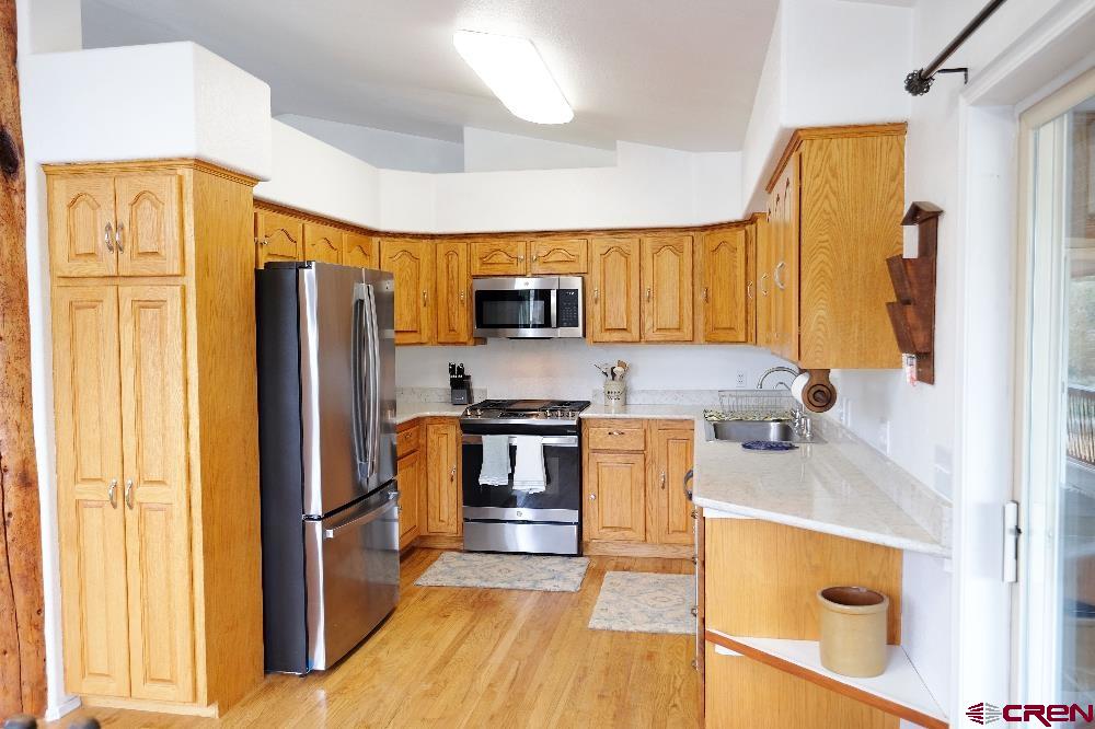 14135 N73 Road Montrose, CO 81401 - Photo 7 of 29 a kitchen with stainless steel appliances granite countertop a refrigerator stove and sink
