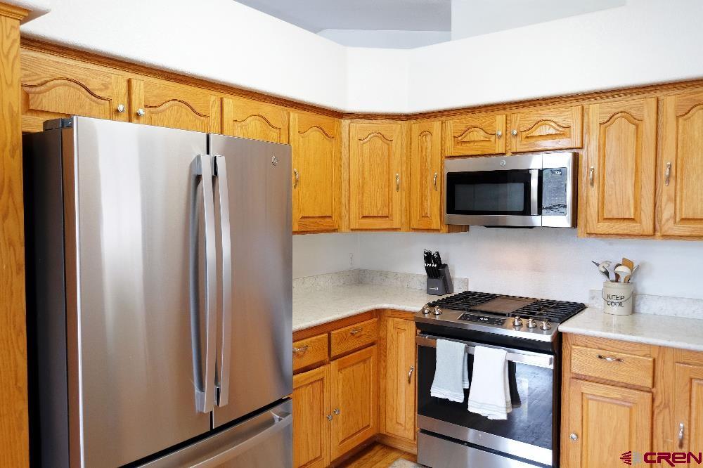14135 N73 Road Montrose, CO 81401 - Photo 8 of 29 a kitchen with stainless steel appliances a refrigerator stove and microwave